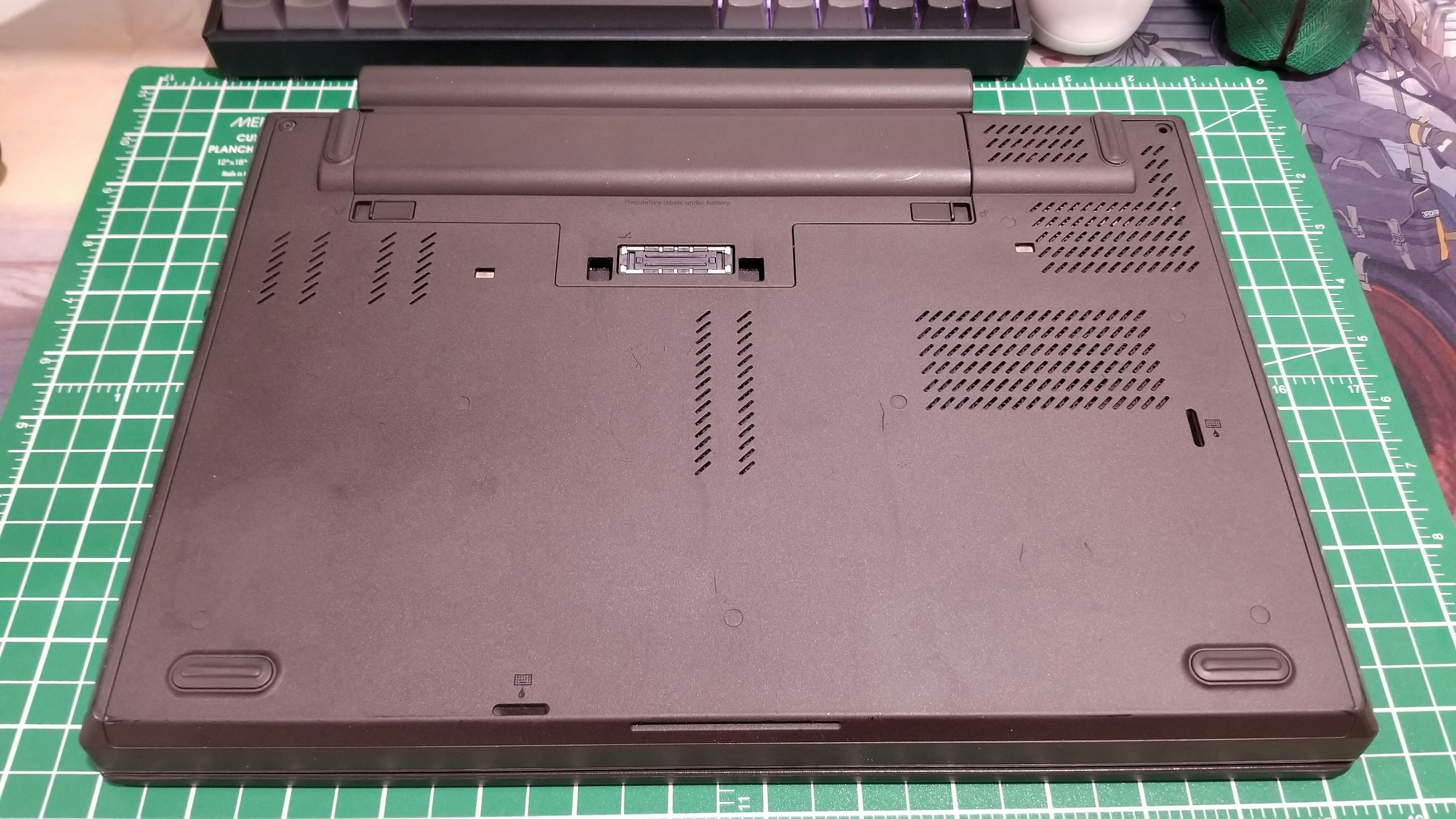 The bottom of a ThinkPad T440p on a work matt.