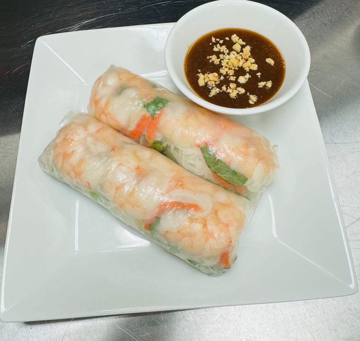 Two summer rolls with peanut sauce.