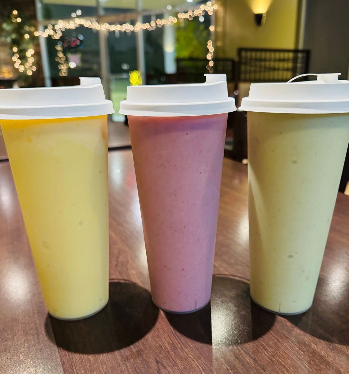 Three smoothies in tall cups.