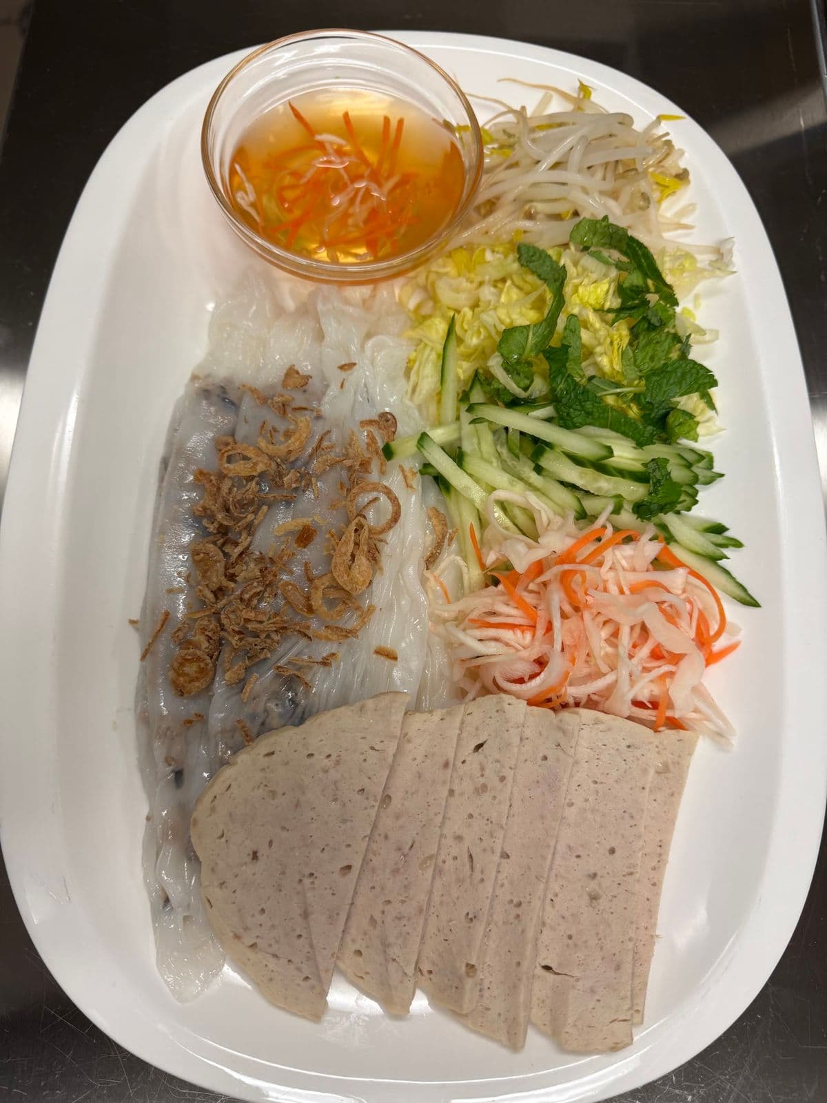 Bánh cuốn with herbs, pickled carrot and sliced pork roll.