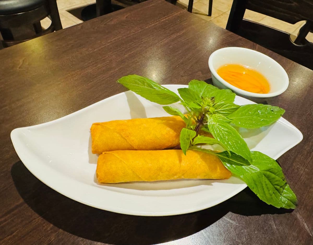 Fried spring rolls with basil and a dipping sauce.