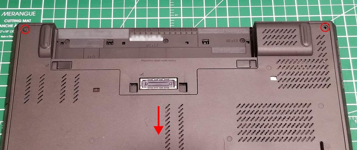 The bottom of a ThinkPad T440p with two screw highlighted and the direction to remove the service panel.